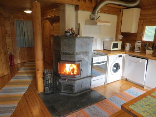 a fireplace in a kitchen with a stove at Cottage-karaoke Koivikko in Äänekoski