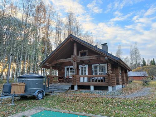 una cabaña de madera con un camión estacionado frente a ella en Cottage-karaoke Koivikko en Äänekoski