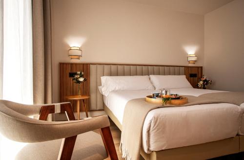 Pokój hotelowy z łóżkiem i krzesłem w obiekcie Hotel Cigarral Santa María w mieście Toledo