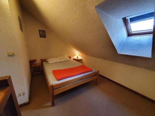 Cette petite chambre mansardée comprend un lit. dans l'établissement Pleiades - D137 - Appart belle vue - 6 pers, à Les Deux Alpes