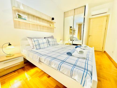 un dormitorio con una cama con sábanas azules y blancas en Lavender Bay Apartment C21, en Donji Morinj
