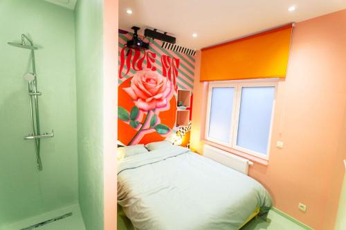 ein kleines Zimmer mit einem Bett und einer Blume an der Wand in der Unterkunft Capsule Flower - Balneo - Cinema - Billard - Nintendo Switch - Mons Centre in Mons