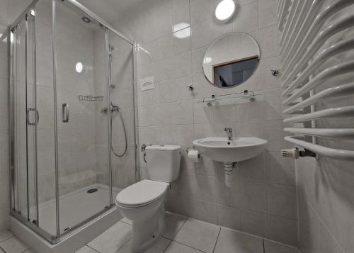 a bathroom with a toilet and a shower and a sink at Hotel Tor Kielce in Kielce