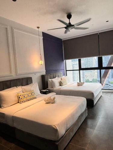 a bedroom with two beds and a ceiling fan at Scarletz Comfy Suites KLCC by MOMO in Kuala Lumpur