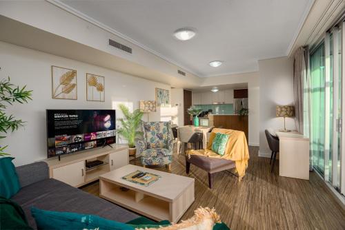 a living room with a couch and a tv at Oasis Retreat Level 27 in Casino Towers in Brisbane