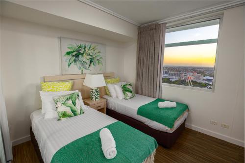 a hotel room with two beds and a window at Oasis Retreat Level 27 in Casino Towers in Brisbane