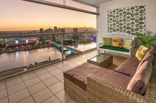 a balcony with a couch and a view of a city at Luxury Oasis with Indulgent River Views in Brisbane