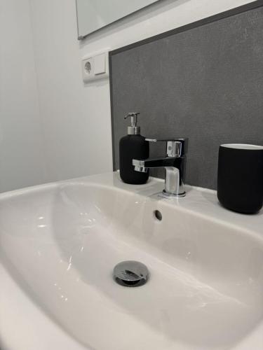 a white bathroom sink with a soap dispenser on it at Edersee Apartment Seeblick 2 in Waldeck