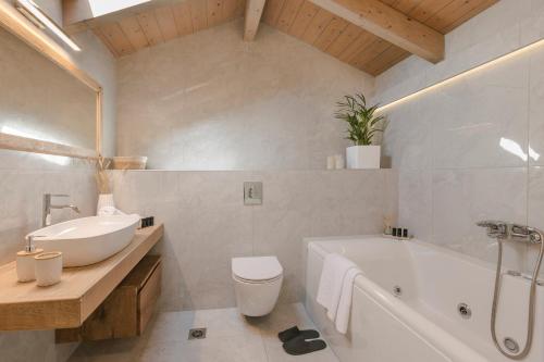 a bathroom with a tub and a sink and a toilet at Kefalonia Luxury Maisonette in Argostoli