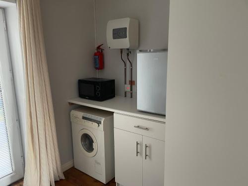 a kitchen with a washing machine and a refrigerator at Lakeland Midsummer Lakehouse in Oughterard
