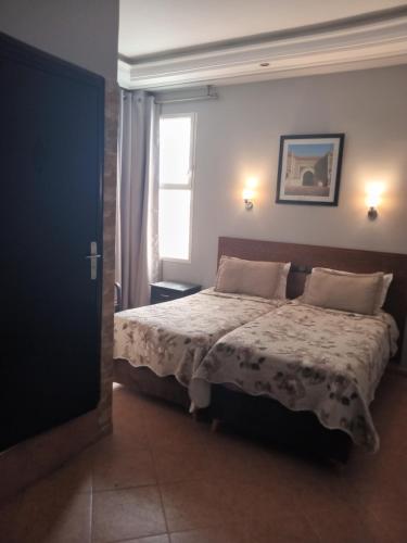 un dormitorio con una cama y una ventana en Hotel Darna, en Rabat
