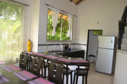 a kitchen with a table with chairs and a refrigerator at Condominio Atlantis in Coveñas