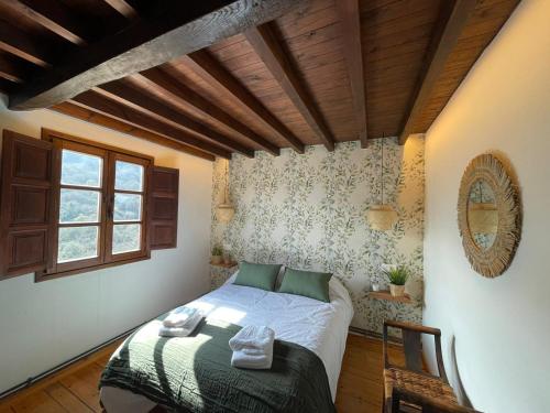 um pequeno quarto com uma cama e uma janela em Entre horreos em Carbajal
