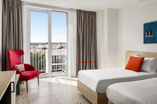 a hotel room with two beds and a window at Quadro Hotel, Trademark Collection by Wyndham in St Julian's