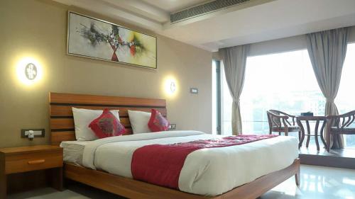 a bedroom with a bed and a large window at HOTEL APOLLO GRAND A UNIT OF SATYAM ASSOCIATES in Guwahati