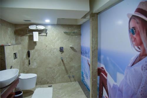 a woman standing in a bathroom with a sink at HOTEL APOLLO GRAND A UNIT OF SATYAM ASSOCIATES in Guwahati