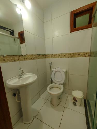 a bathroom with a sink and a toilet and a mirror at Pousada Viva Praia in Paracuru