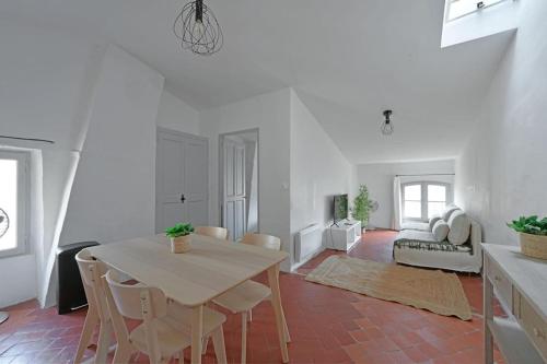 un salon blanc avec une table et des chaises dans l'établissement Brugnotte - Wi-Fi - Proche THEaTRES, à Avignon