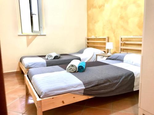 een kamer met drie bedden en handdoeken erop bij La Terrazza sul Mare in Siculiana Marina