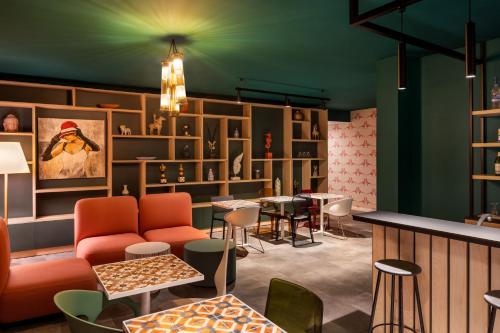 a room with chairs and tables and a bar at Quadro Hotel, Trademark Collection by Wyndham in St Julian's