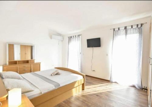 1 dormitorio blanco con 1 cama y TV en Luxury house Marone, en Isquia