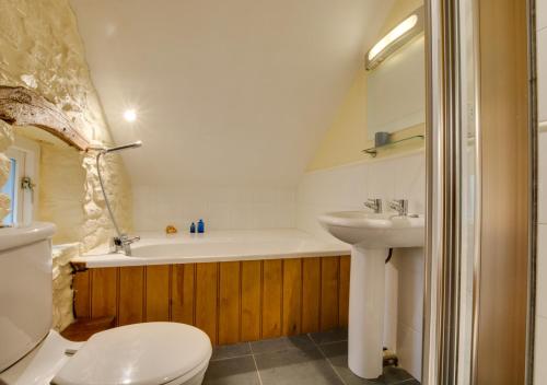 a bathroom with a sink and a tub and a toilet at Corn Loft in Solva