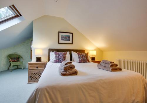 a bedroom with a bed with towels on it at Corn Loft in Solva