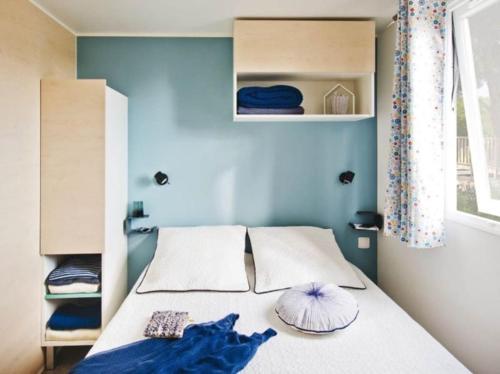 a bedroom with a bed with blue walls at Camping 2 Plages et Océan in Châtelaillon-Plage