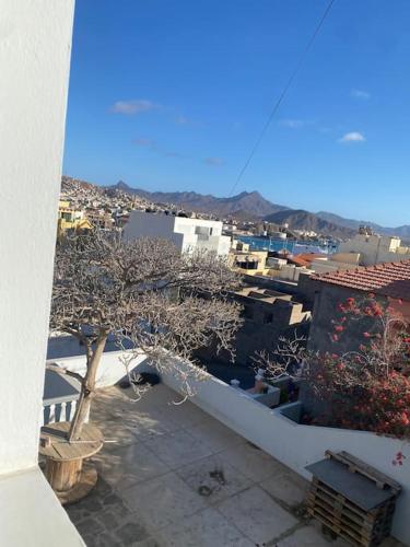 a view of a city with a tree on a balcony at Vivenda com pátio, no coração do Mindelo in Mindelo