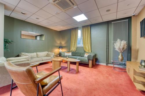 a living room with a couch and a table at Hôtel Escurial - Centre Gare in Metz