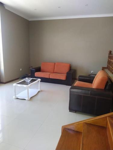 a living room with two couches and a coffee table at Vivenda com pátio, no coração do Mindelo in Mindelo