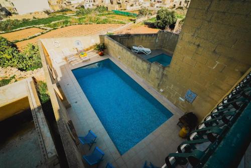 an overhead view of a swimming pool with blue water at Villa Getaway with Private Pool in Sannat