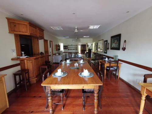 a dining room with wooden tables and chairs at Figtree Lane Lodge in Richards Bay