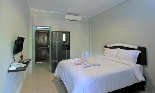 una camera da letto con un letto con due peluche sopra di Jazz Senggigi Hotel a Senggigi