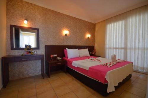 a bedroom with a large bed and a mirror at ADMİRAL HOTEL in Kizkalesi