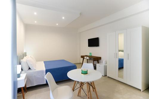 a bedroom with a bed and a table and a tv at Dorant Charme&Rooms in Vieste