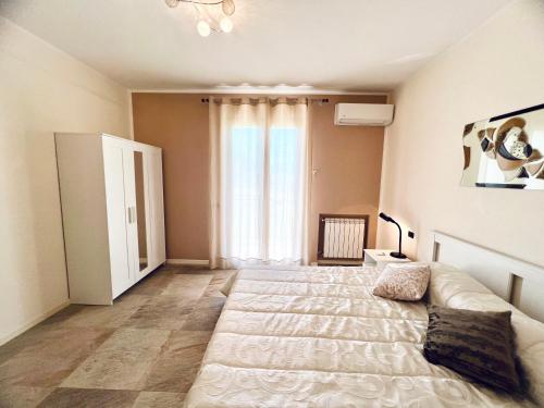 a bedroom with a large bed and a large window at Rosa di Mare in Capaci