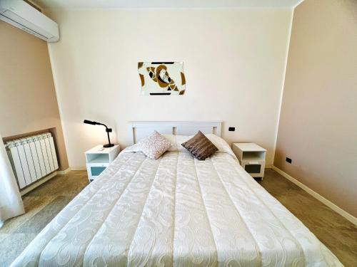 a bedroom with a large white bed with two night stands at Rosa di Mare in Capaci