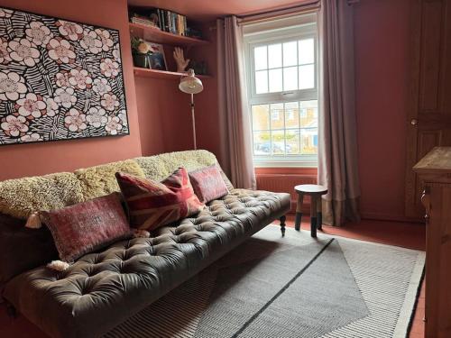 a living room with a couch and a window at Spring Crescent Cottage in Rye in Rye