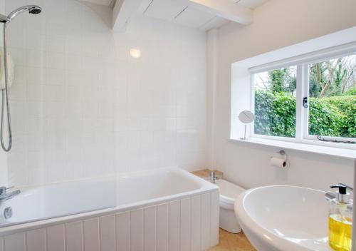Baño blanco con bañera y lavamanos en Crown Cottage, en Dolgellau
