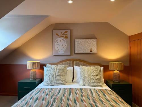 a bedroom with a bed with two night stands and two lamps at Spring Crescent Cottage in Rye in Rye