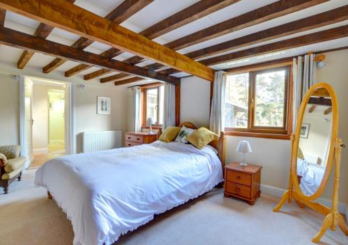 a bedroom with a large bed and a mirror at Tynddol Isaf in Pentre-briwnant