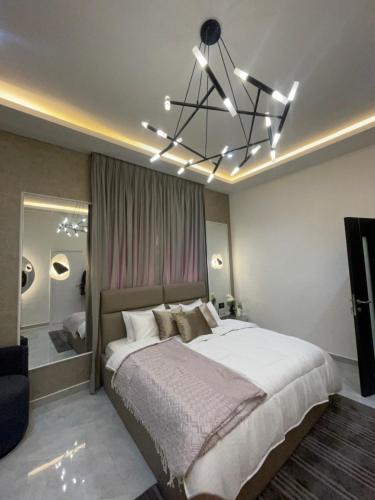 a bedroom with a large bed and a chandelier at Luxury Airport residential in Accra