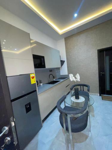 a kitchen with a table and a refrigerator at Luxury Airport residential in Accra