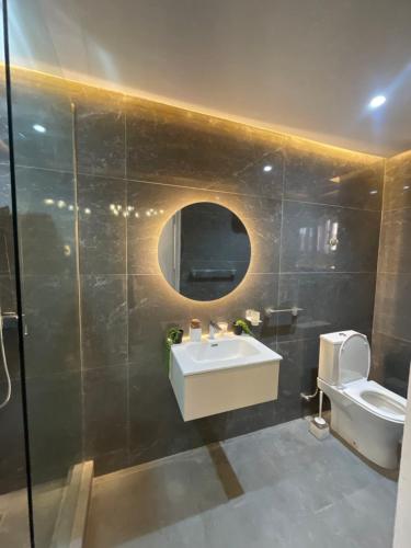 a bathroom with a sink and a toilet and a mirror at Luxury Airport residential in Accra