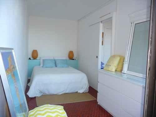 une chambre blanche avec un lit et une fenêtre dans l'établissement Le Barcarès - Appartement 3 pièces avec piscine et parking proche plage - FR-1-782-7, au Barcarès