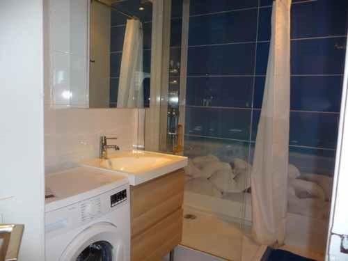 une salle de bain avec une machine à laver et un lavabo dans l'établissement Le Barcarès - Appartement 3 pièces avec piscine et parking proche plage - FR-1-782-7, au Barcarès