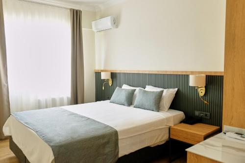 a bedroom with a large bed with two pillows at Grand Keskin Otel in Denizli