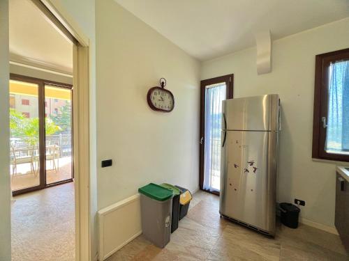 a kitchen with a refrigerator and a clock on the wall at Rosa di Mare in Capaci