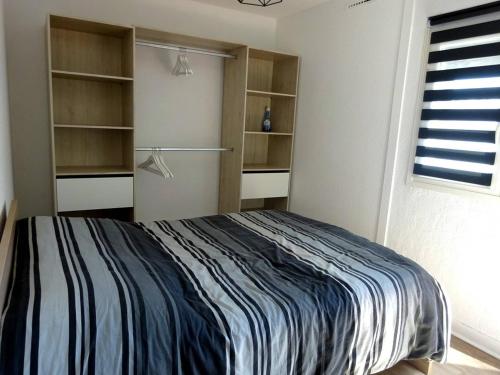 - une chambre avec un lit, des étagères et une fenêtre dans l'établissement Appartement 2 pièces avec terrasse au bord de l'eau, parking, climatisation - FR-1-782-1, au Barcarès